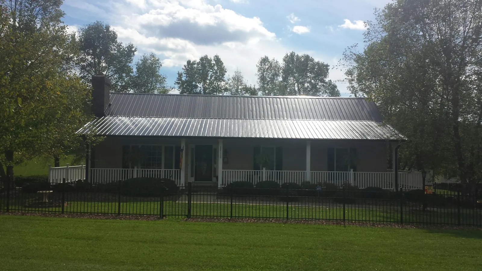 Gray metal roof on a brick ranch with a full width front porch — Gutter Guard Installation work by our crew in Wallingford